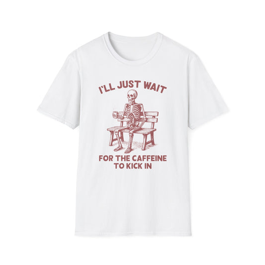 White color t-shirt with ’I’ll Just Wait For The Caffeine To Kick In’ text on top and bottom of a skeleton seating on a wooden bench and holding a freshly made coffee on a mug design on a white background