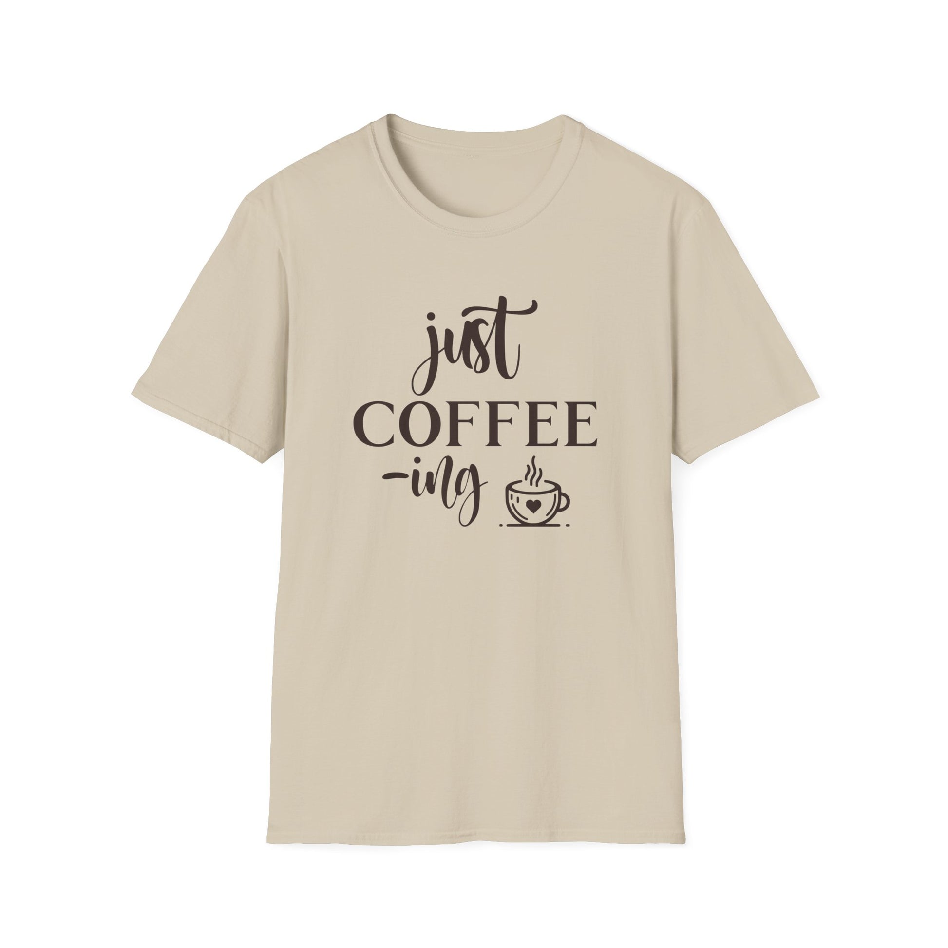 Sand t-shirt with ’Just Coffee -ing’ text and a freshly made coffee on a mug with a heart design on a sand color background