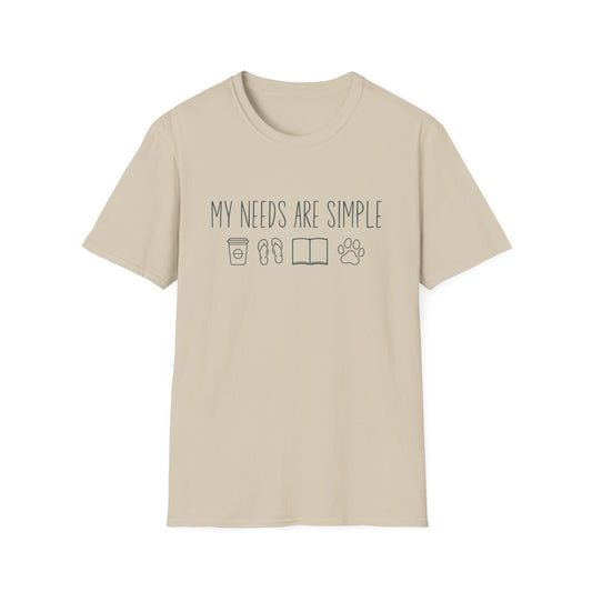 Sand t-shirt with ’My Needs Are Simple’ text on top of four icons showing a to go cup of coffee a pair of flip flops an opened book and a dog paw lineal style design on a sand color background